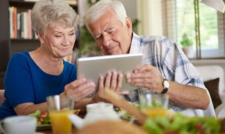 couple de senior qui utilise une tablette lors du petit dejeuner