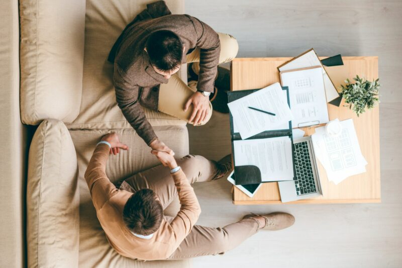 vu du dessus de deux hommes qui ont conclu une affaire et se font une poignée de main