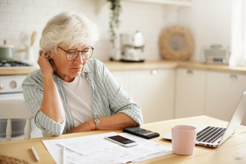 femme agée qui calcul ses dépenses du mois