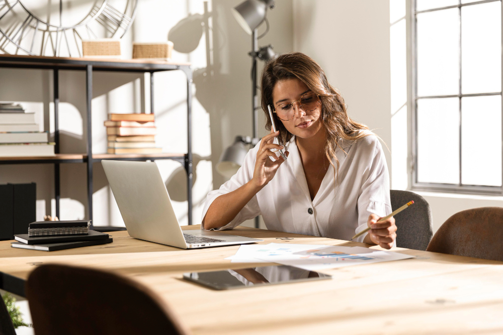 femme au téléphone derrière son bureau