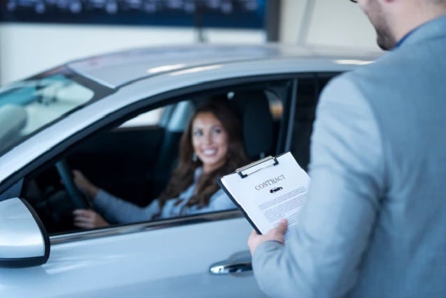 Homme tenant un contrat de crédit auto