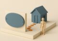 Plaque professionnelle vierge en maquette devant une petite maison, les deux achats immobiliers d'une profession libérale